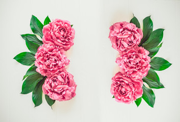 Flower border pattern frame made of bright pink buds peony bouquet on a white wooden background. Floral texture mockup. Flat lay, top view. Peony texture. Vintage, retro toning image. Copy space.