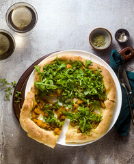 traditional Italian white pizza with taleggio cheese, caramelized pumpkin and arugula on the table