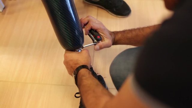 Unrecognizable professional man assembling a knee prosthesis in his workshop