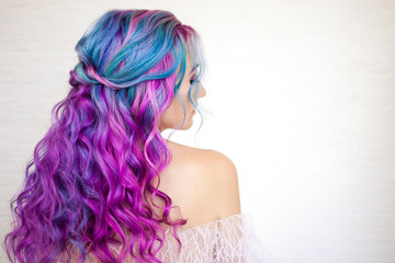 Naklejka premium Back view of stylish youth girl with bright hair coloring, Ombre with blue purple shades.