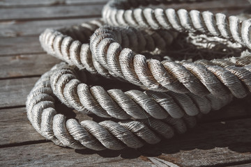 Naklejka premium Close up of worn out thick mooring rope on wooden pier. Can use as banner