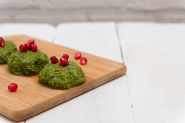 Traditional Georgian dish pkhali made of spinach, walnuts, vinegar, onions, garlic and herbs. Image with copy space.