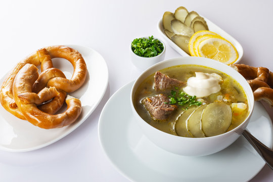 Soup Rassolnik with pickled cucumber and sour cream on a white background. Russian cuisine. Close up. Selective focus. For the menu.