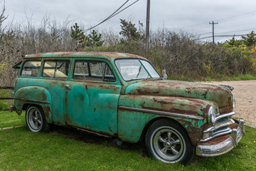 side view of an old rusting car with neon green exterior