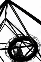 Black and white picture of the steel construction of Tetrahedron in german Bottrop taken from below against the sky. The popular landmark, built on a mine dump, serves as a view point