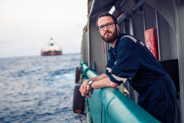 Deck Officer wearing glasses on deck of offshore vessel or ship. Work at sea.