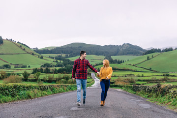 happy couple holding hands and smiling. walk along the road in t