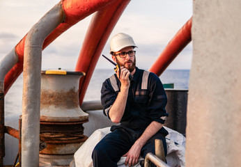 Deck Officer on deck of offshore vessel or ship , wearing PPE personal protective equipment. He...