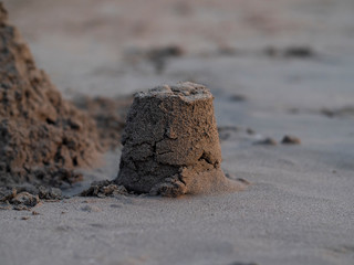 Sand castle/sculpture washing in to the sea as waves slowly eats from it - pictures at sunset on a caribbean beach