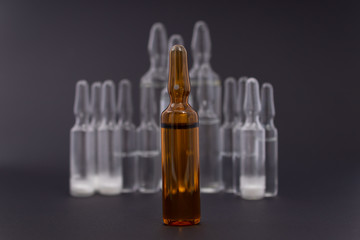Brown ampoule close-up on the background of drugs