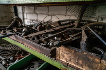 Bunch of old tools in a wooden box on a workshop shelf