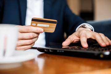 Close up photo of man's hands using credit card and purchasing something on sale.
