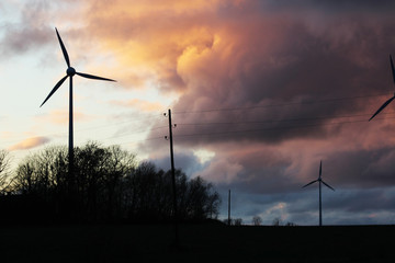 epic autumn sky and green energy, windmills silhouettes