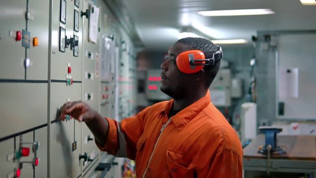 Marine engineer officer in engine control room ECR. Seamen's work. He starts or stops main engine of ship