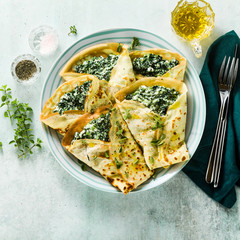 Traditional Italian pancakes crepes with spinach and ricotta on a served table. healthy vegetarian diet