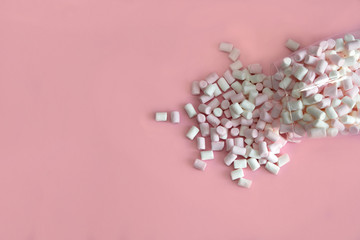 Mini white and pink marshmallow marshmallows. Marshmallows scattered from a glass bowl. Pink background. Place for text. copy space Birthday, Mother's, Valentines, Women's, Wedding Day concept.