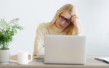 Fototapeta premium Overworked Mature Businesswoman Suffering From Headache In Office
