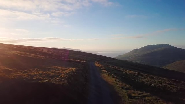 Aerial view of the Valley of Glenmore and the Cooley Mountains during sunset. Drone flying forward at medium speed with a blue sky and the Big River as background.