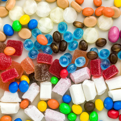 multicolored caramel candies scattered on the table background. sugar products. colored sweets