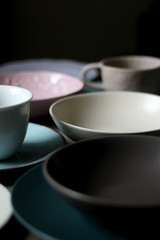 Collection of pottery and kitchenware in muted pastel colors. Selective focus.