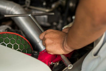 A mechanic service car in garage. Engine repair technicians are hold the wrench in order to repair the car..