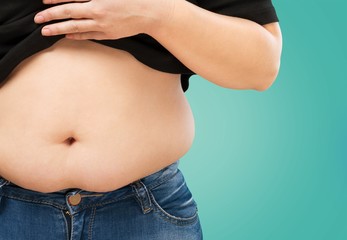 Woman's hand holding excessive belly fat