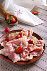 Dumplings, filled with strawberries. Varenyky, vareniki, pierogi, pyrohy - dumplings with filling