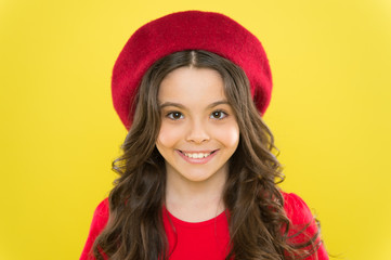 Perfect curls. Kid cute face with adorable curly hairstyle wear beret hat. Little fashionista. Little girl grow long hair. Styling of curly hair. Hairdresser service. Kid girl long healthy shiny hair