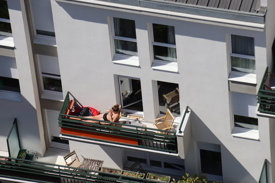 Jeune femme bronzant sur un balcon &agrave; Paris