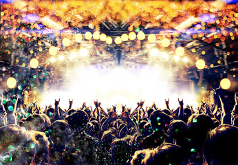 Concert spectators in front of a bright stage with live music