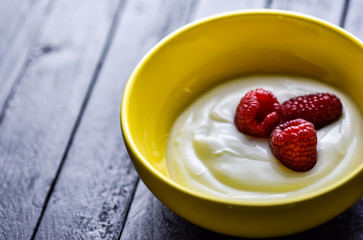 Morning breakfast with tasty berries all on a dark wooden table.