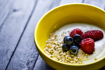 Morning breakfast with tasty berries all on a dark wooden table.