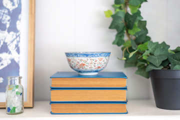 Stack of blue vintage books with oriental rice bowl
