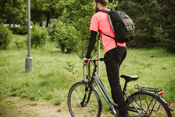 Fototapeta premium A young and handsome man riding a bicycle in the park
