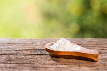 Baking soda, Sodium bicarbonate. Wooden table in the park among the trees on a summer day. Text...