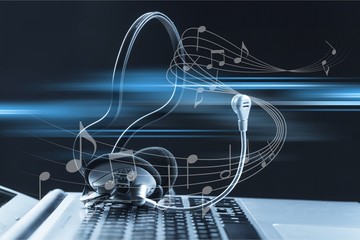 Computer headphones with laptop  on background
