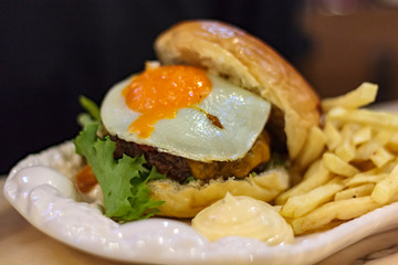 Meat Burger with Egg and french fries with sauce on a plate