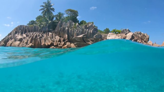 Split view of underwater and paradisiacal landscape of St. Pierre Island coral reef in Seychelles. Snorkeling exploring sealife of Indian Ocean, under and above water photography.