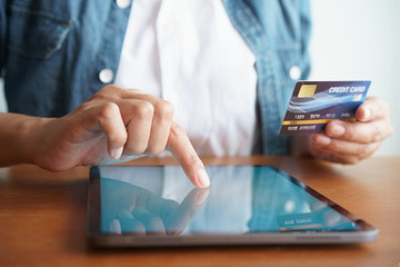 Close up hand of businessmen are buying online with a credit card. Men are using tablet and doing online transactions.