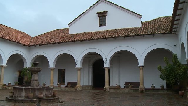 Handheld, panning, exterior, medium wide shot of the common area of the Chuquisaca Governorship Palace.