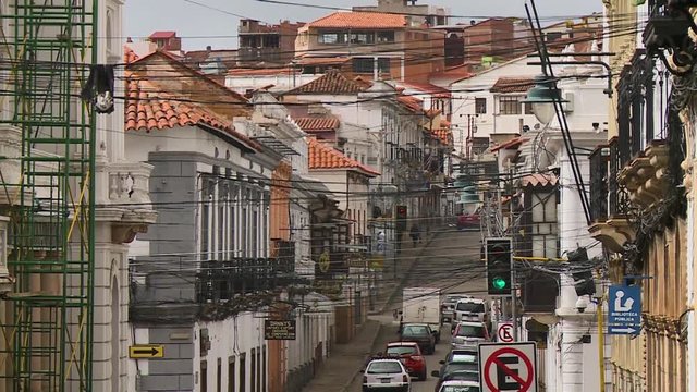Steady, exterior, medium closeup shot of a city street with a lot of power lines stretched across from building to building. In the city of Sucre, Bolivia.