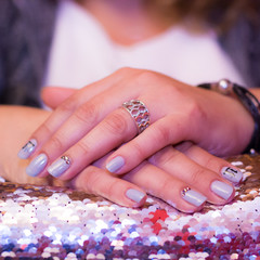 Grey manicure with gloss on a shiny background