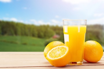 Naklejka premium Orange juice and slices of orange on background