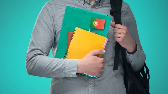 Student holding notebooks with Portuguese flag, international education program