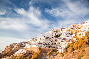 Obraz premium beautiful Oia town on Santorini island, Greece. Traditional white architecture and greek orthodox churches with blue domes over the Caldera, Aegean sea. Scenic travel background