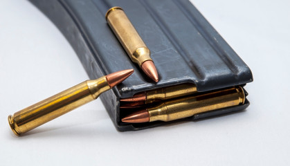Naklejka premium A metal 223 caliber rifle magazine loaded with 223 caliber bullets with two bullets on top of it isolated on a white background