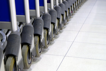 Wheels of shopping cart in row on white tile