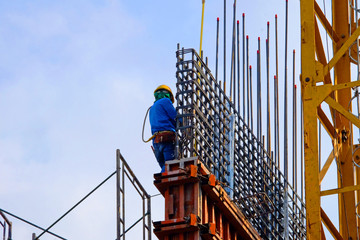 Foreman worker in safety uniform working on construction site with copy space