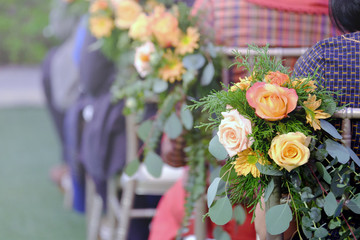 Colorful flowers decorated behind the chair at wedding ceremony
