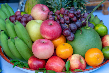 Assortment of fresh fruit banana, grapes, orange, apple, pineapple, tangerine and grapefruit on a tray. Closeup